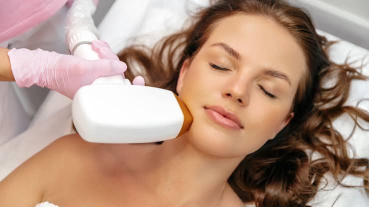 Illustrative photograph of a laser handpiece on the face.